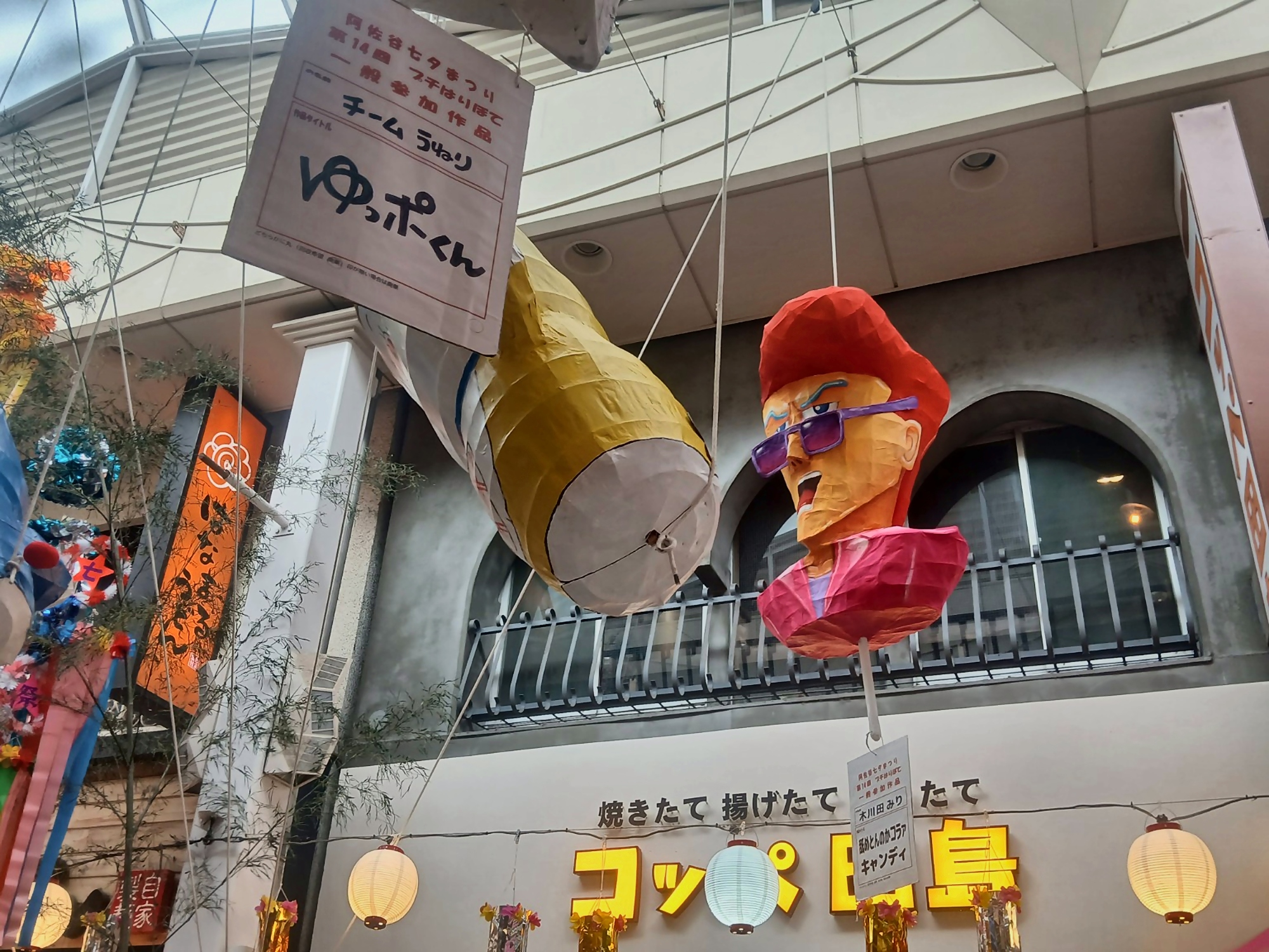 Large figures hanging above the shops of Asagaya